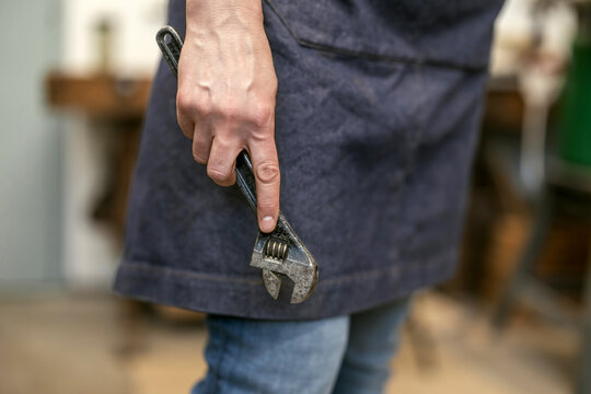 Carpenter Holding Wrench Tool in Workshop
