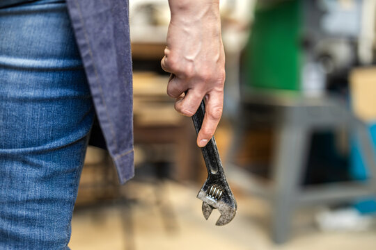 Carpenter Holding Wrench Tool in Workshop
