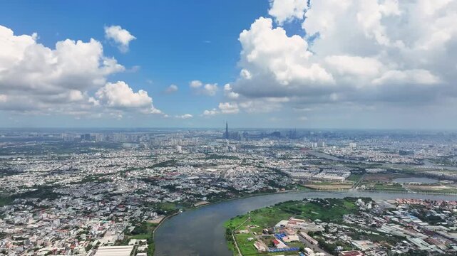 Forward drone flight over Ho Chi Minh City skyline with Landmark 81 and Saigon River under blue sky, Vietnam