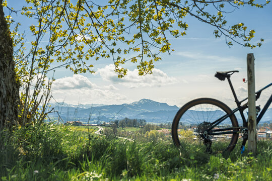 Bicycle parked on a hill overlooking Kempten and the Gruenten mountain, Allgau, Germany. Scenic view of the Alps with a mountain bike in the foreground under a blue spring sky. Active lifestyle.