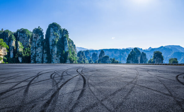 Empty asphalt road with tire tracks leading to sandstone peaks in Zhangjiajie, Hunan, China