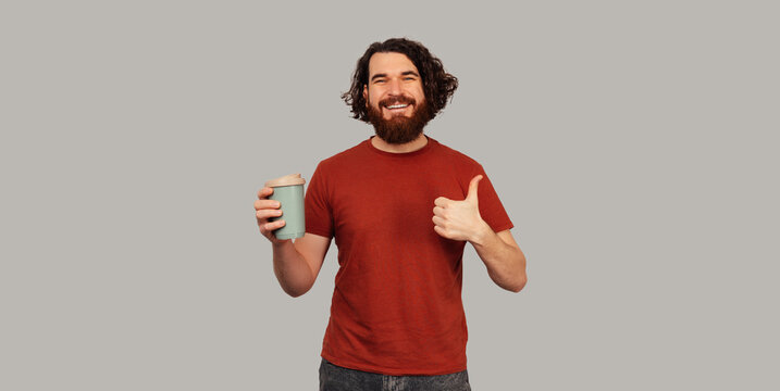 Caucasian Man Holding Disposable Coffee Cup And Giving Thumbs Up, Bearded Morning Enthusiast In Red Shirt