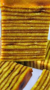 Slices of Indonesian Lapis Legit Layer Cake or Spekkoek on White Plate, Traditional Authentic Thousand Layers Spiced Butter Cake for Festive Celebration, Eid Al-Fitr, and Lunar New Year Photography.