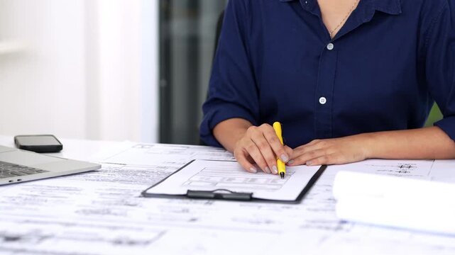 Site Enginee working in construction site office reviews daily work report. Engineer, Architectural concept.