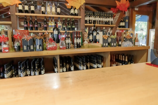Blurred Wine display with bottles and gifts at a shop during autumn season near a forested area