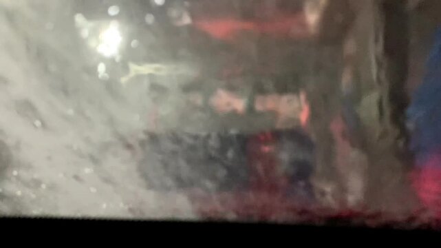 POV Automatic Car Wash Process with Soap Suds Covering and Water Rinsing Windshield 4K