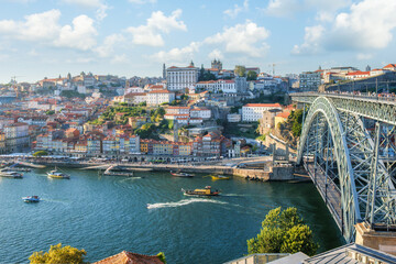 Obraz premium High angle view of the Dom Luis I bridge and the Douro river with several boats and the Ribeira district Porto Portugal.