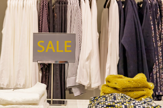 Clothes on display with sale sign at a retail store during a shopping event in the afternoon