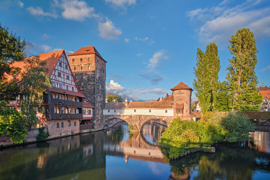 Beautiful reflections of the historic Henkersteg bridge and half-timbered houses in the Pegnitz river, Nuremberg, Germany.