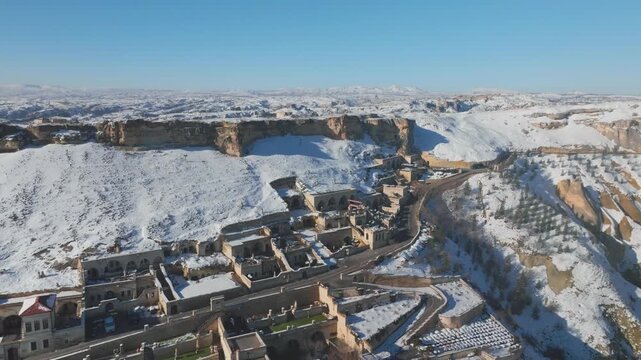 Aerial drone above Urgup, valley viewpoint in &Uuml;rg&uuml;p, Cappadocia, Turkey, revealing, snowy hills and wide Anatolian panorama under a vivid blue sky