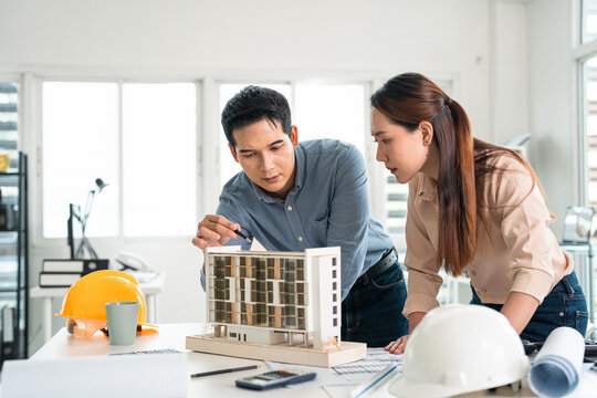 Engineering, meeting on blueprint and building model with people in office for construction, Collaboration, review and teamwork with group in architecture firm for project management.