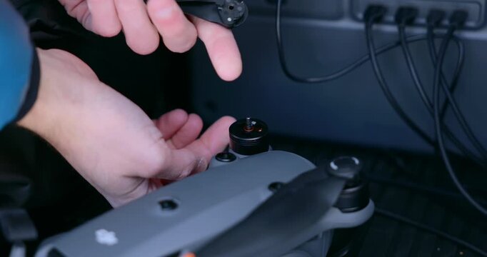 Hands adjusting the propeller of a DJI Mavic drone during pre flight maintenance