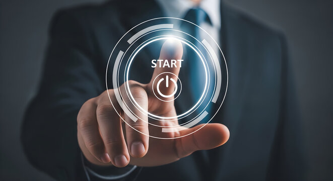 Businessman in suit activates technology start button with finger.