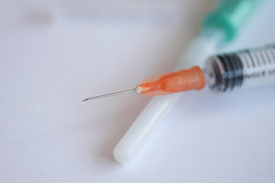 Close-up of a insulin syringe on top of a white table. Medicine and healthcare concept.