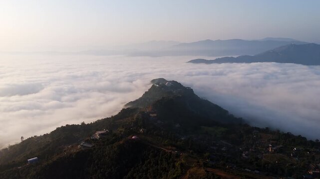 AERIAL: Dramatic cloud sea over Phewa lake valley, morning dawn in Himalayas