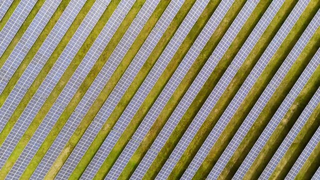 Screwdriver drone shot rotating and rising above solar panels in France, summer