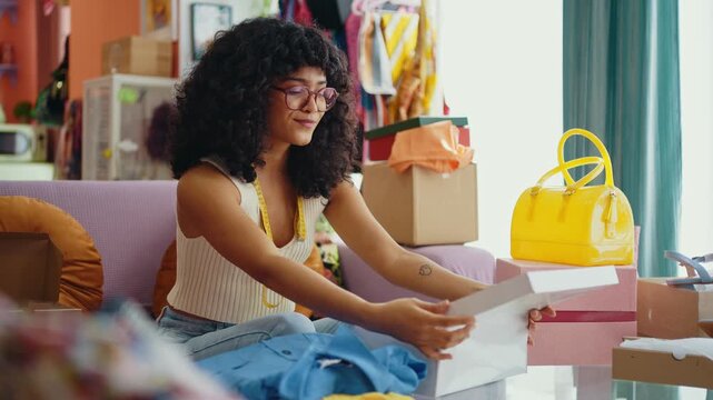 Beautiful young hispanic woman managing her home clothing e-commerce business from home - Female designer owns online shopping store, concepts of home business and reselling second hand accessories