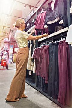 Woman choosing casual outfit in clothing store