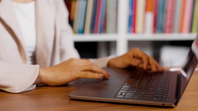 Close up businesswoman using laptop trackpad at desk in office