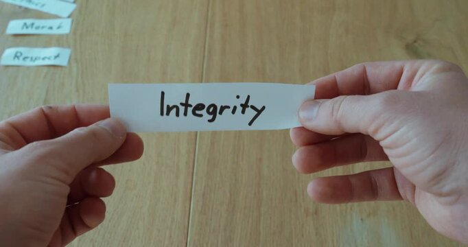 Hands holding a paper labeled &ldquo;Integrity,&rdquo; representing honesty, values, and strong moral principles.