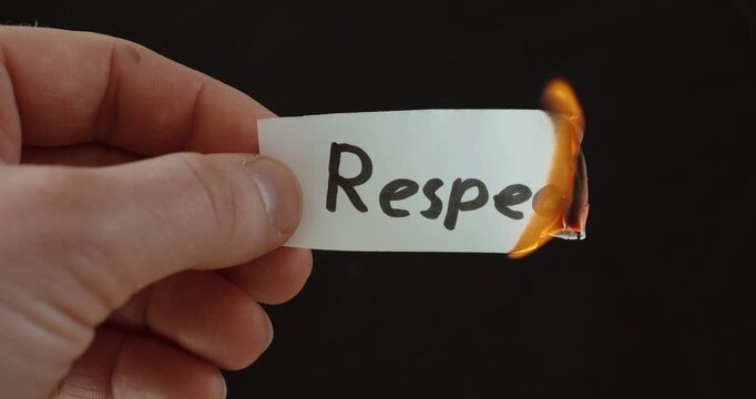 Hand burning a paper labeled &ldquo;Respect,&rdquo; symbolizing loss of values, broken trust, and emotional conflict.