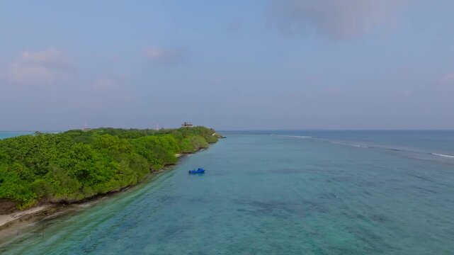 Smooth low aerial drone footage flying along the tropical jungle of Vashafaru Island with endless palm trees and beautiful island scenery in northern Maldives.