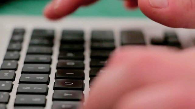 Freelancer or office employee working remotely on a computer using a wireless keyboard.
