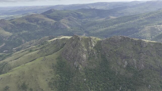 Drone orbits left in ultra wide shot of left side of Sheba's Breast mountain peak on overcast afternoon in Ezulwini Valley, Eswatini