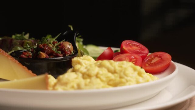 Delicious and healthy Turkish breakfast plate with assorted cheeses, scrambled eggs, and fresh vegetables, fa01