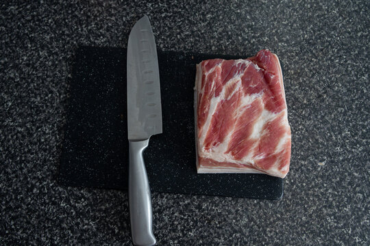 Filete de carne cruda con marmolejo de grasa natural sobre una tabla y un cuchillo 