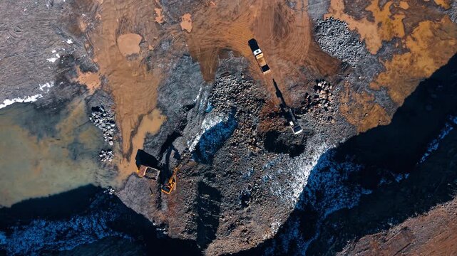 Active site with heavy machinery. Heavy machines operate at a construction site. Workers move earth and materials.