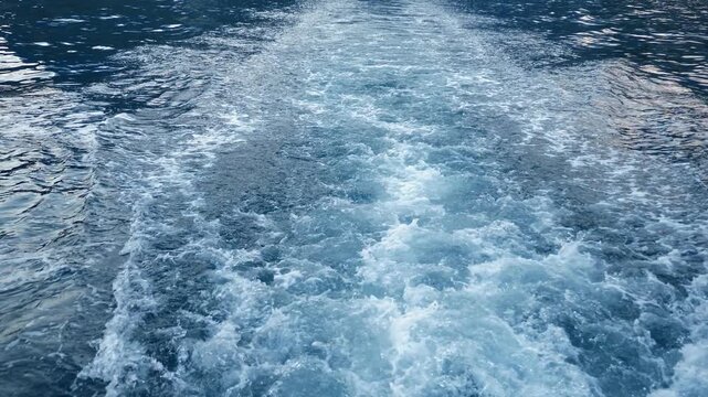Close-up of the seething water in the sea behind the ship. The sea. A splash of sea waves behind a large boat on the sea. Slow motion.