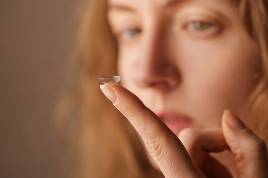 Contact lens on fingertip before insertion for vision correction and eye care