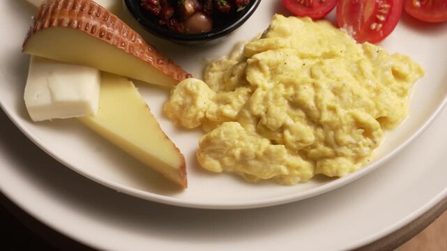 Delicious and healthy Turkish breakfast plate with assorted cheeses, scrambled eggs, and fresh vegetables, fa01