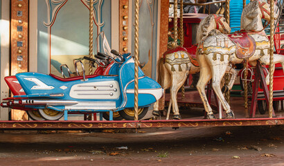 Motorcycle and horses on a vintage carousel at a fairground in the afternoon sun © kinovo