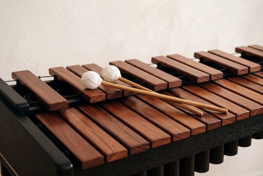 Wooden marimba keyboard with two white yarn mallets