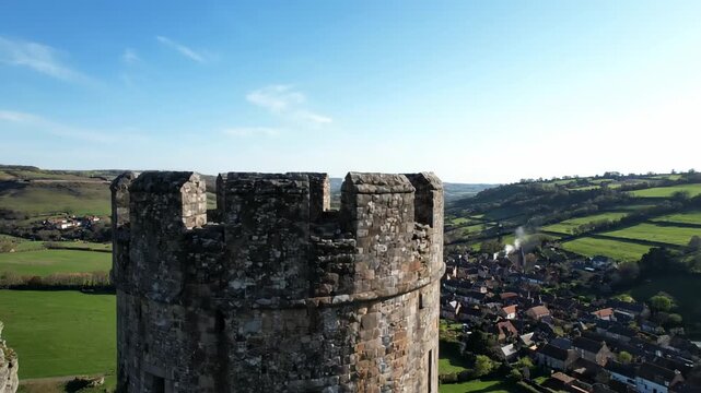Aerial shot of an old stone castle tower overlooking the countryside