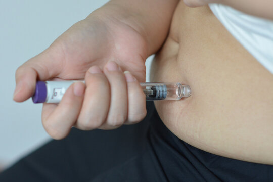 Hand Holding Weight Loss Injection Pen, Medical Treatment and Healthcare Copcept.