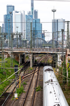 Frankfurt Bankenviertel rail corridor with train and railway lines beneath skyline skyscrapers where urban transportation infrastructure connects Germany financial city
