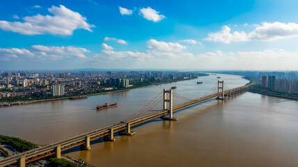 Fototapeta premium An aerial satellite image captures a large car on a bridge over a river with a cityscape in the background