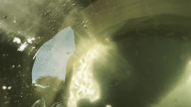 Close-up of water moving inside a container, creating ripples and dynamic patterns that highlight fluid motion and vibration