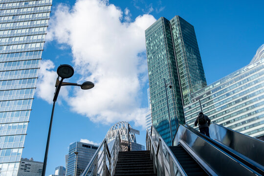Silhouette on an escalator in La Defense paris where modern architecture and urban skyscrapers shape skyline for finance and business life