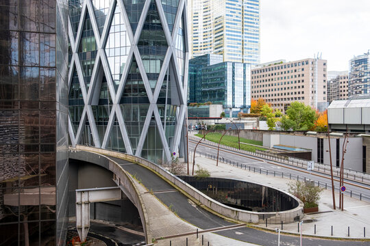 Urban overpass frames modern glass architecture as skyscrapers shape skyline in La Defense Paris financial business district in daylight