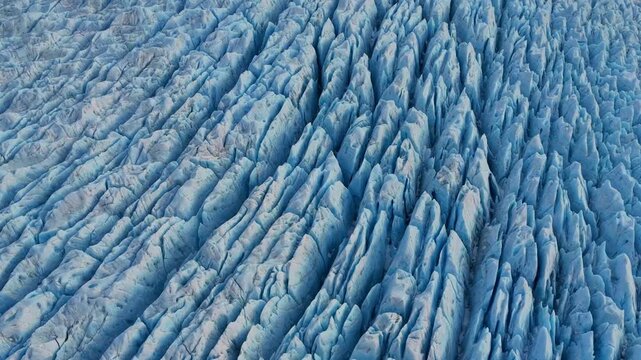 Aerial view of a glacier's icy expanse, etched with deep crevasses and painted in shades of blue and white, Alaska, United States.