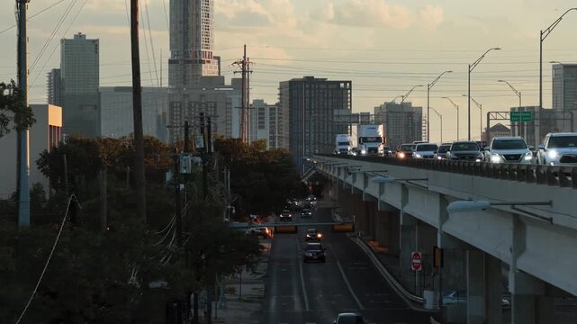 Aerial Drone Flies Alongside Elevated I-35 Traffic With Austin Skyline at Sunset