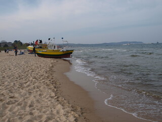 Obraz premium Fishing Boats on Sandy Beach in Sopot with Calm Baltic Sea Waves