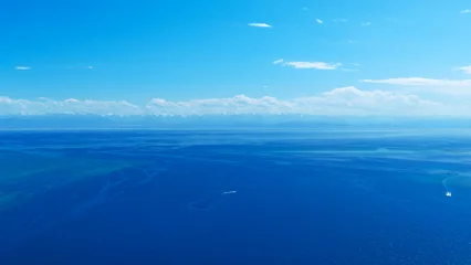 Aerial view of boats on vast blue ocean with mountains © lucky pics