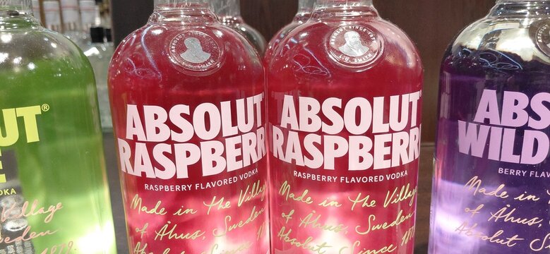 8 January 2026, Istanbul, Turkiye: Absolut Raspberry flavored vodka bottles displayed next to other colorful spirits in a retail store