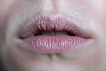 Fototapeta premium Subject: A close-up of a person’s lips. Action: Lips are slightly parted, with visible texture and natural lip color. Setting: A dark background.