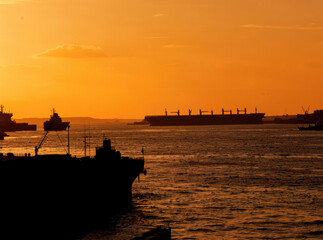 Obraz premium Large ship sailing on calm water during sunset, a serene and peaceful scene
